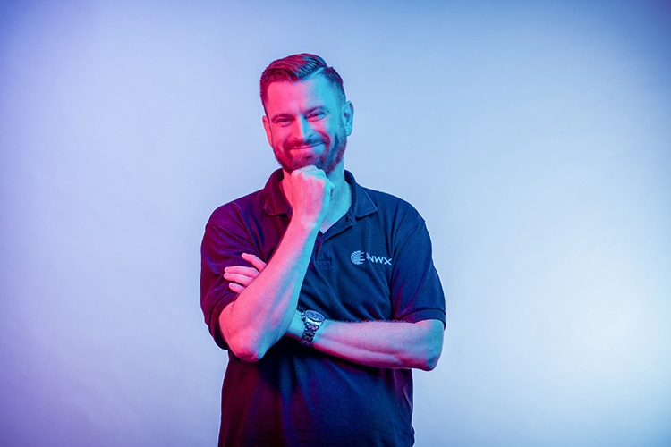 Man holds hand to chin and smiles