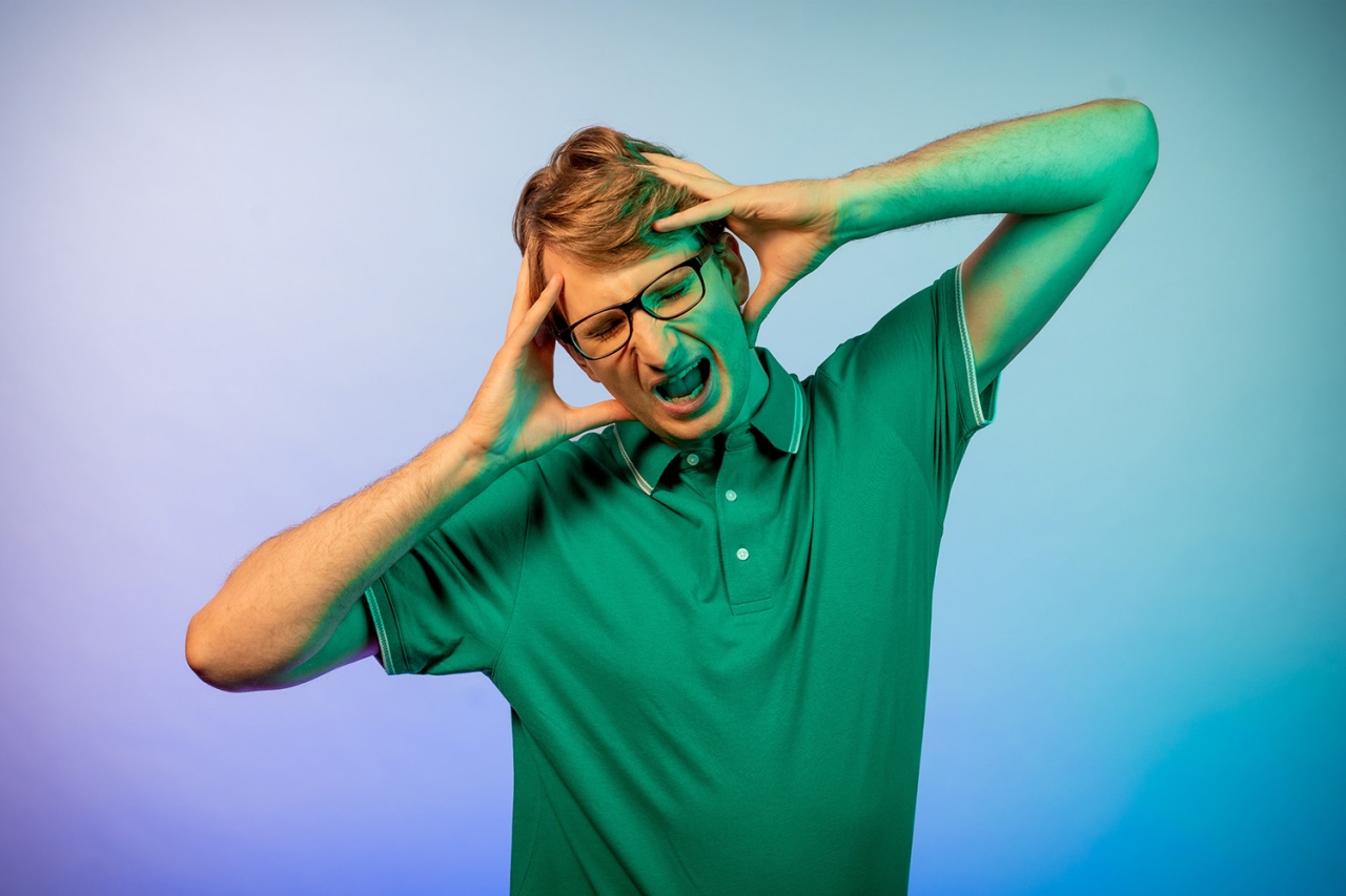 Man with both his hands on his head, screaming